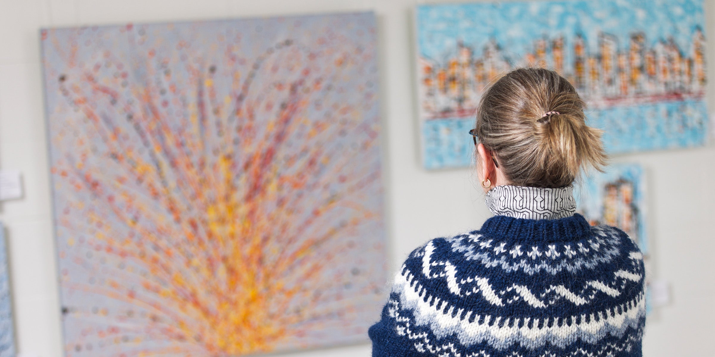 Person viewing abstract artwork at an exhibition